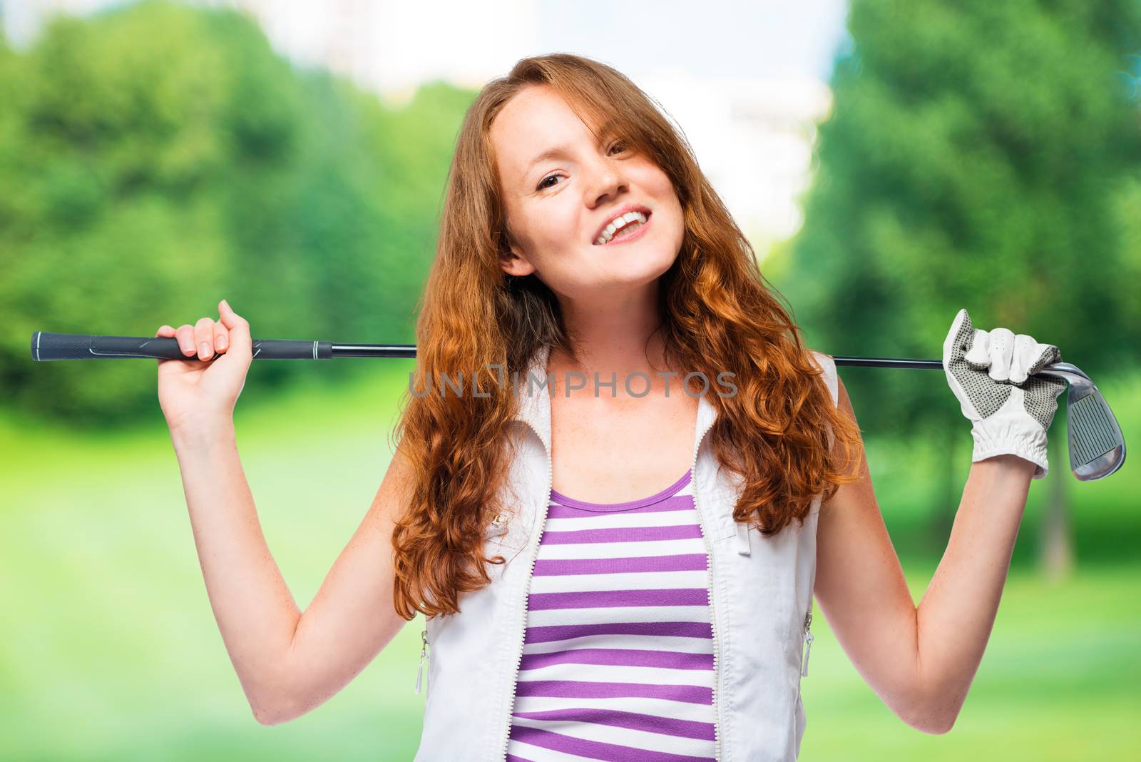 Women with a golf club on their shoulders on a background of golf courses