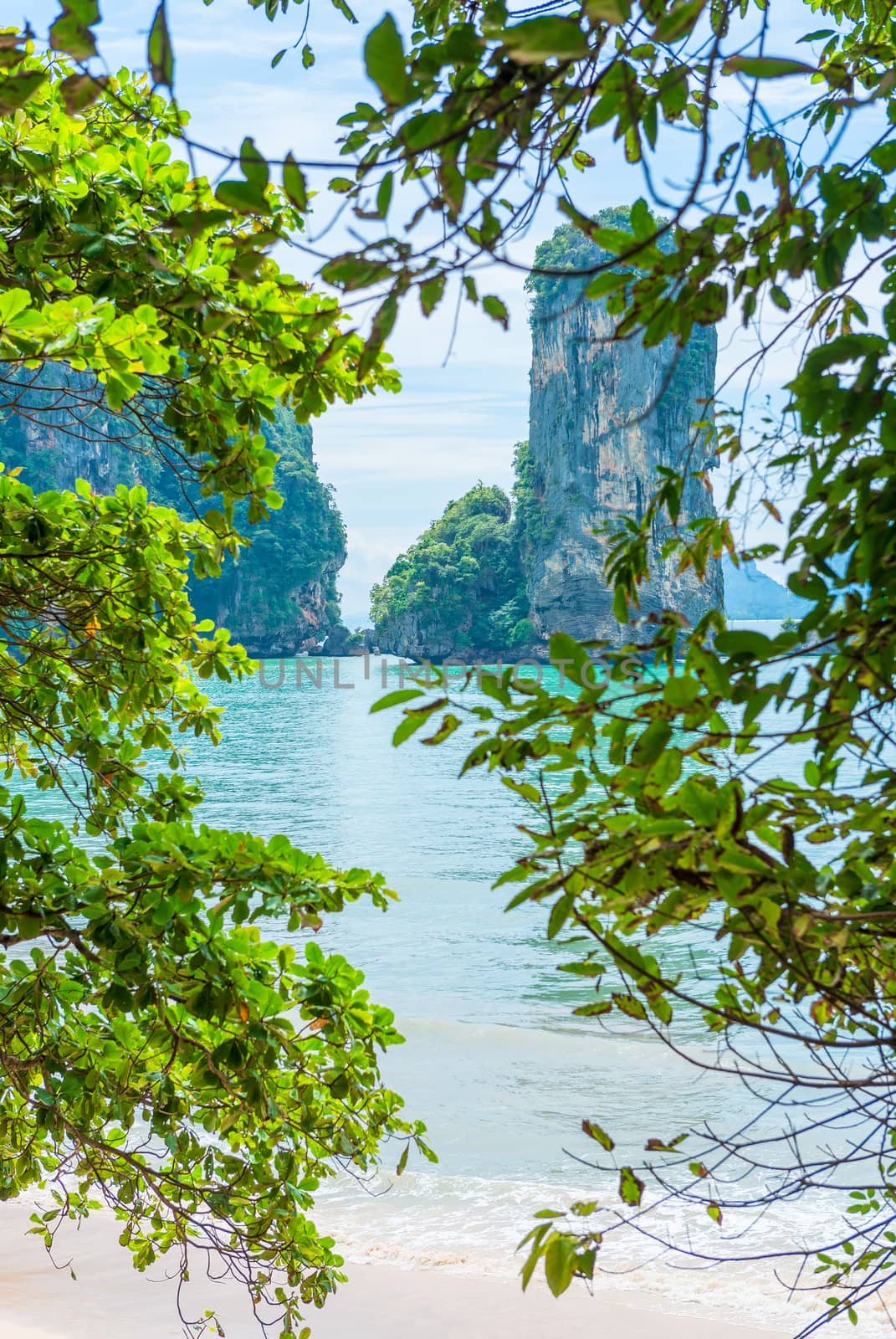 beautiful view through the tree to the bay in the Andaman Sea and the rock