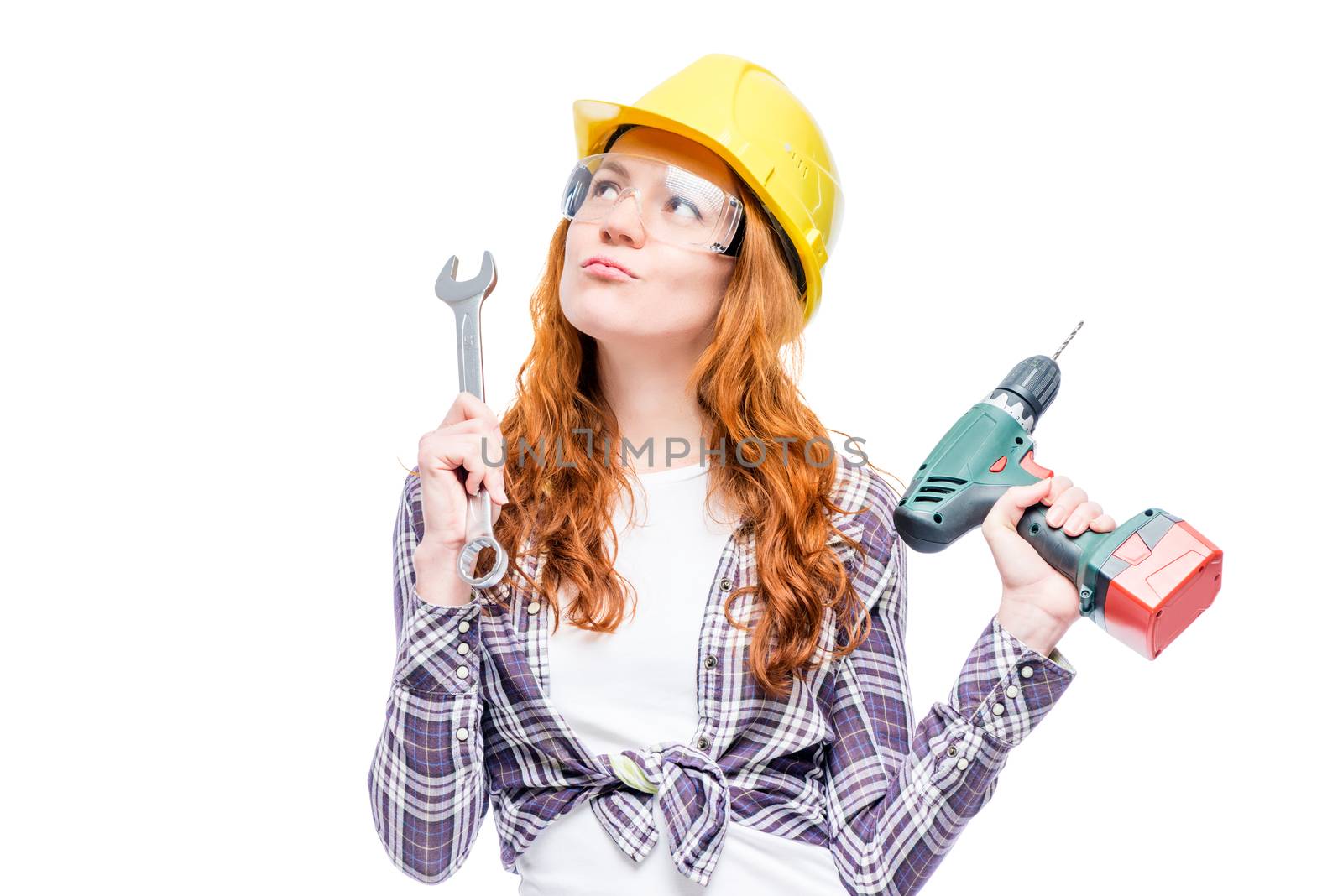 pensive woman carpenter in helmet on white background with tools