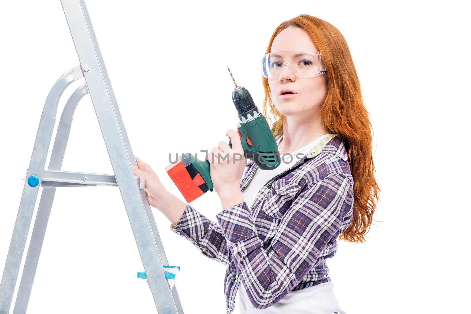 girl with a drill on a stepladder posing on a white background