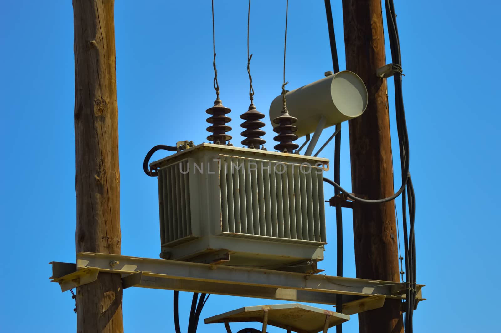 Electric transformer on wooden pylons with an arrival and several departures and countless recreations