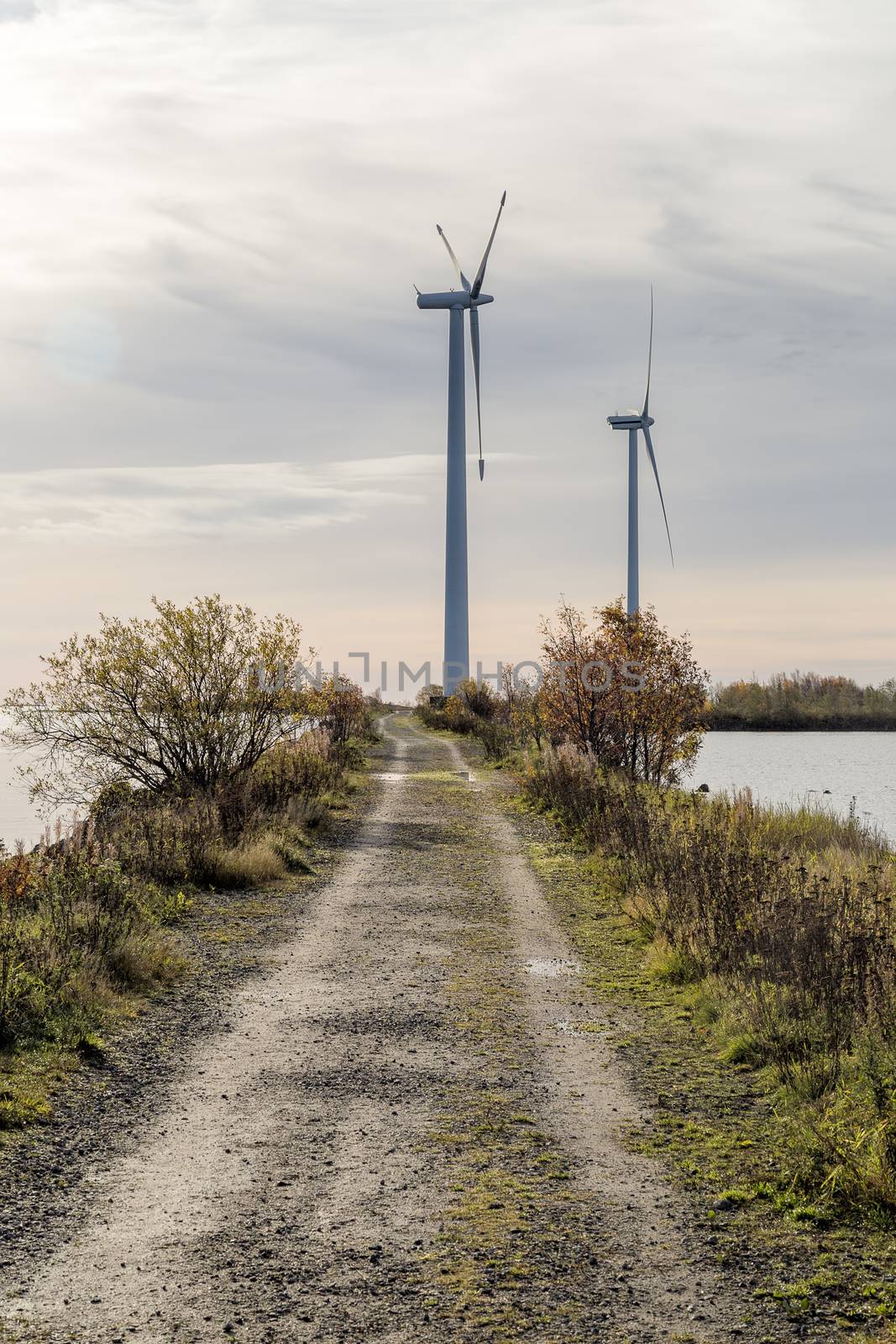 Wind Power Stations by Gravel Road and Ocean.