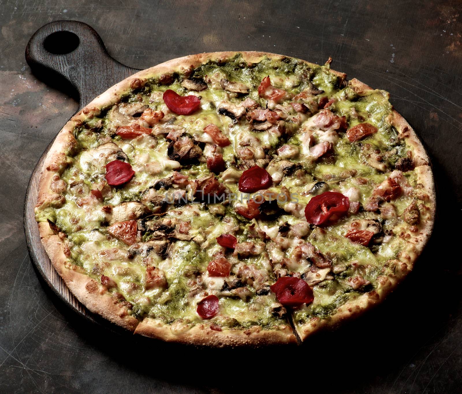 Delicious Homemade Pizza with Bacon, Cheese, Roasted Bell Pepper, Zucchini and Alfredo Sauce on Wooden Cutting Board closeup on Grange Dark background