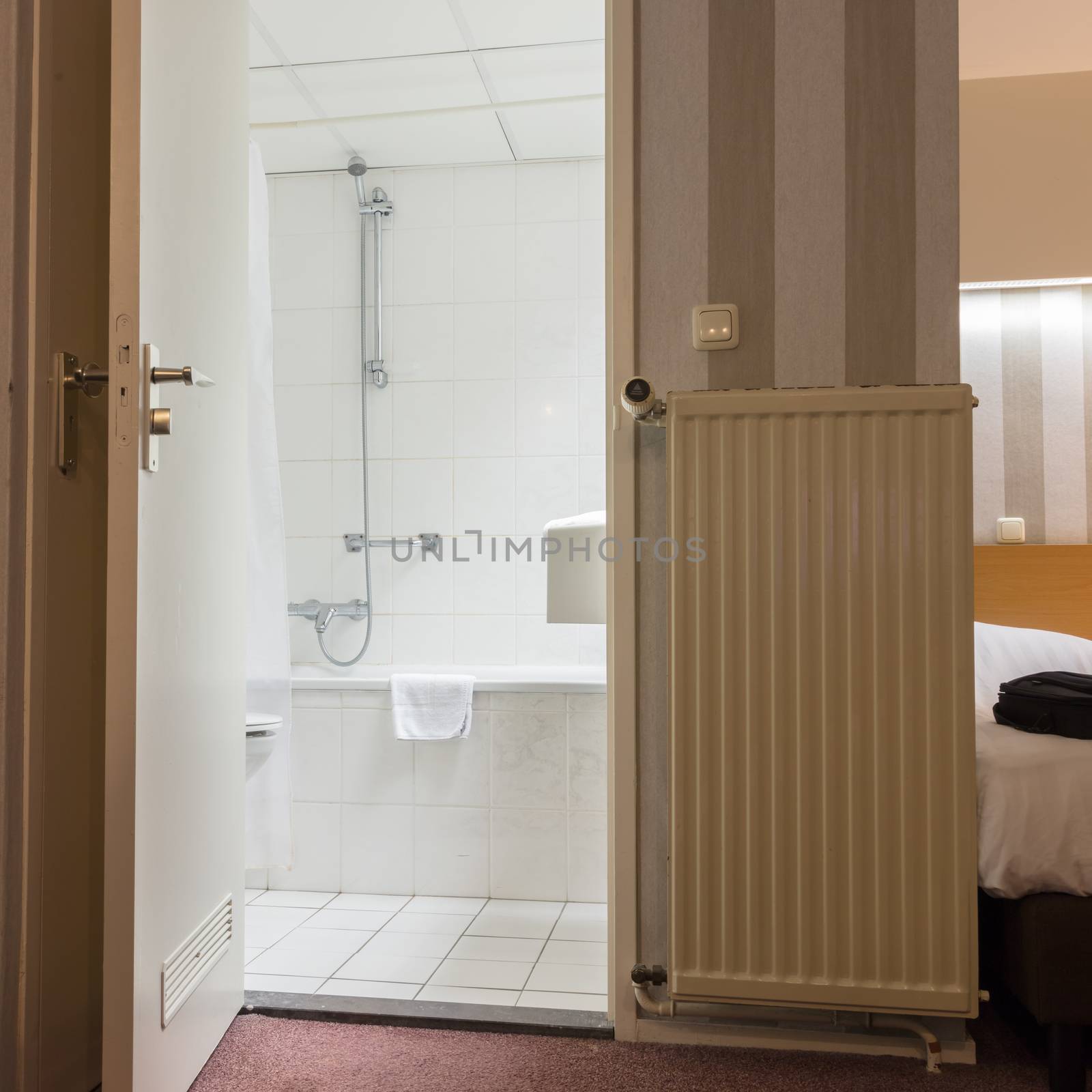 Inside a simple hotel room - Door to the bathroom is open