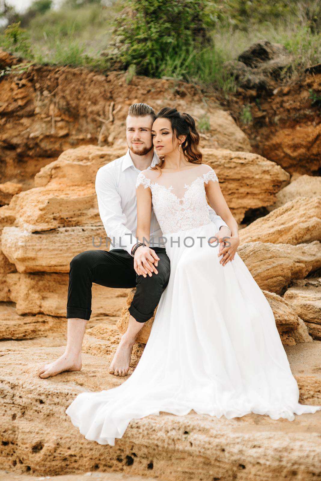 young couple groom with the bride on a sandy beach at a wedding walk