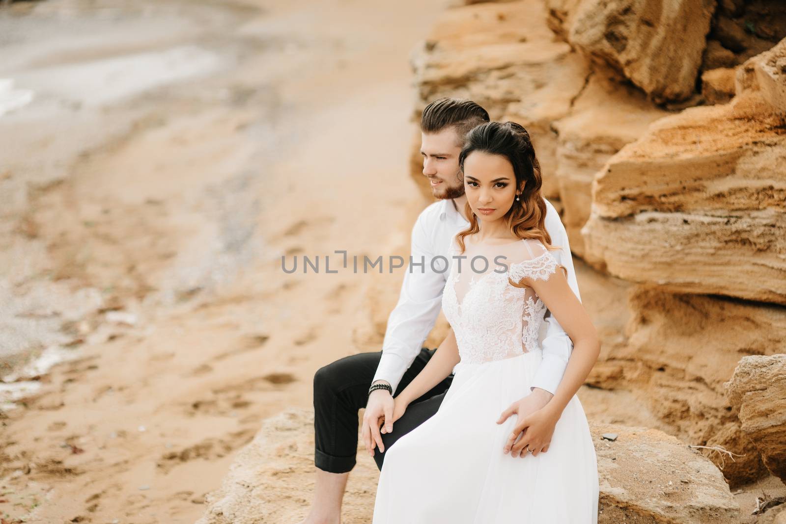 young couple groom with the bride on a sandy beach at a wedding walk