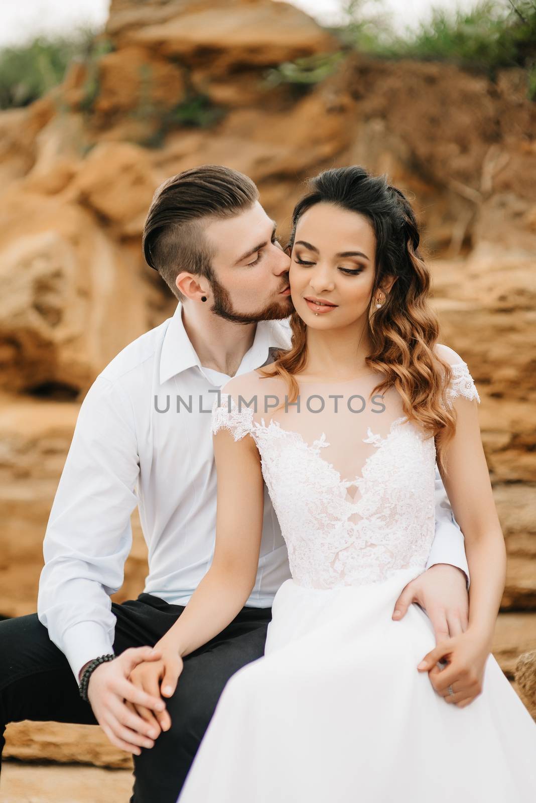 young couple groom with the bride on a sandy beach at a wedding walk