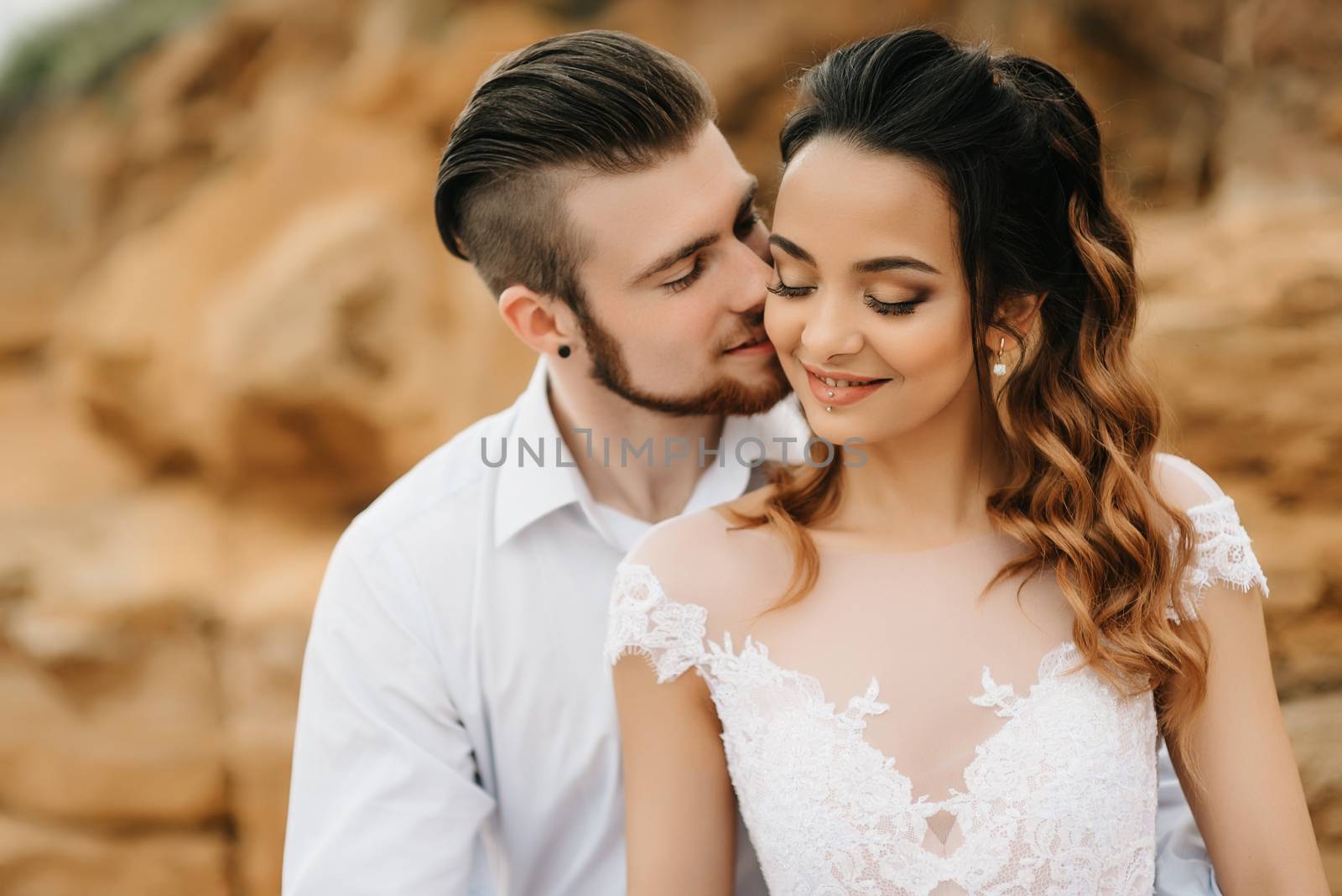 young couple groom with the bride on a sandy beach at a wedding walk