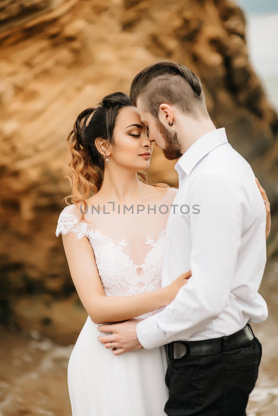 young couple groom with the bride on a sandy beach at a wedding walk