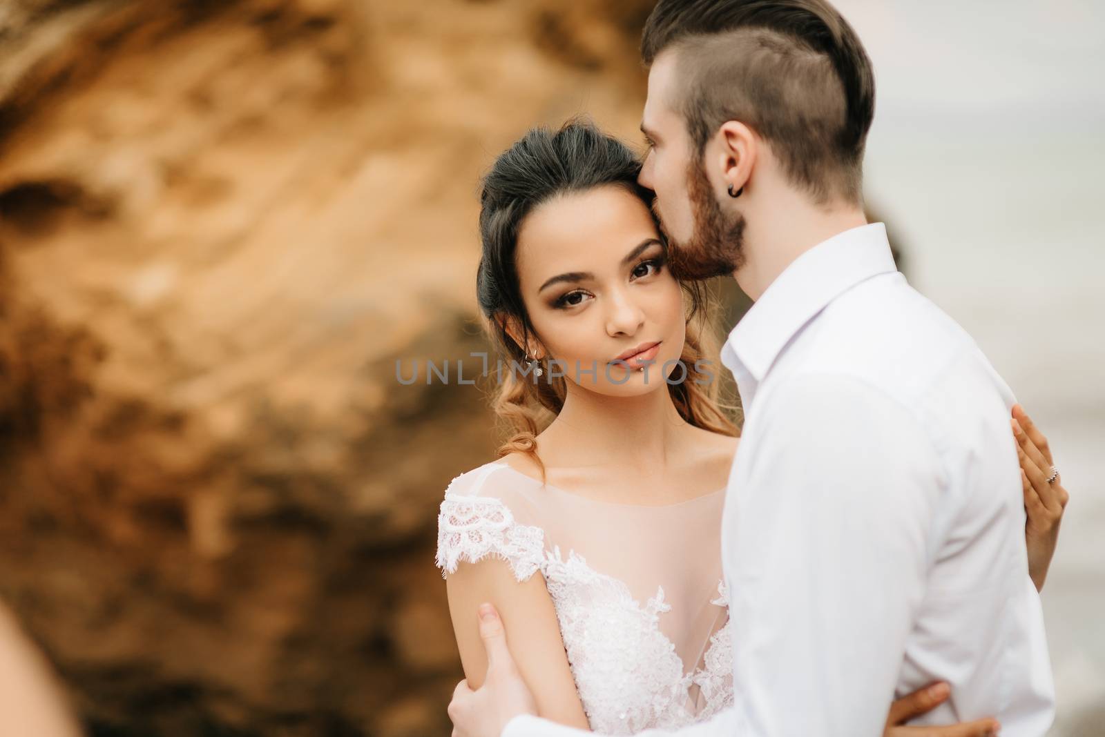 young couple groom with the bride on a sandy beach at a wedding walk