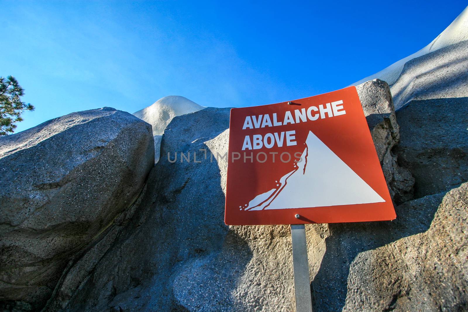 An Avalanche Above sign with rocks behind