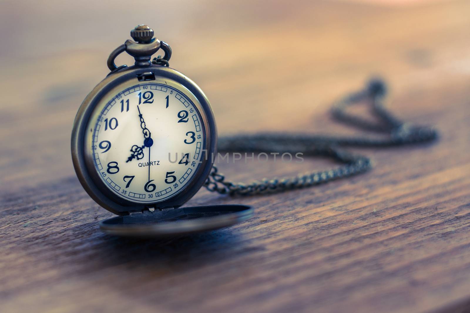 pocket watch on the old wooden table with copy space, concept time and work 