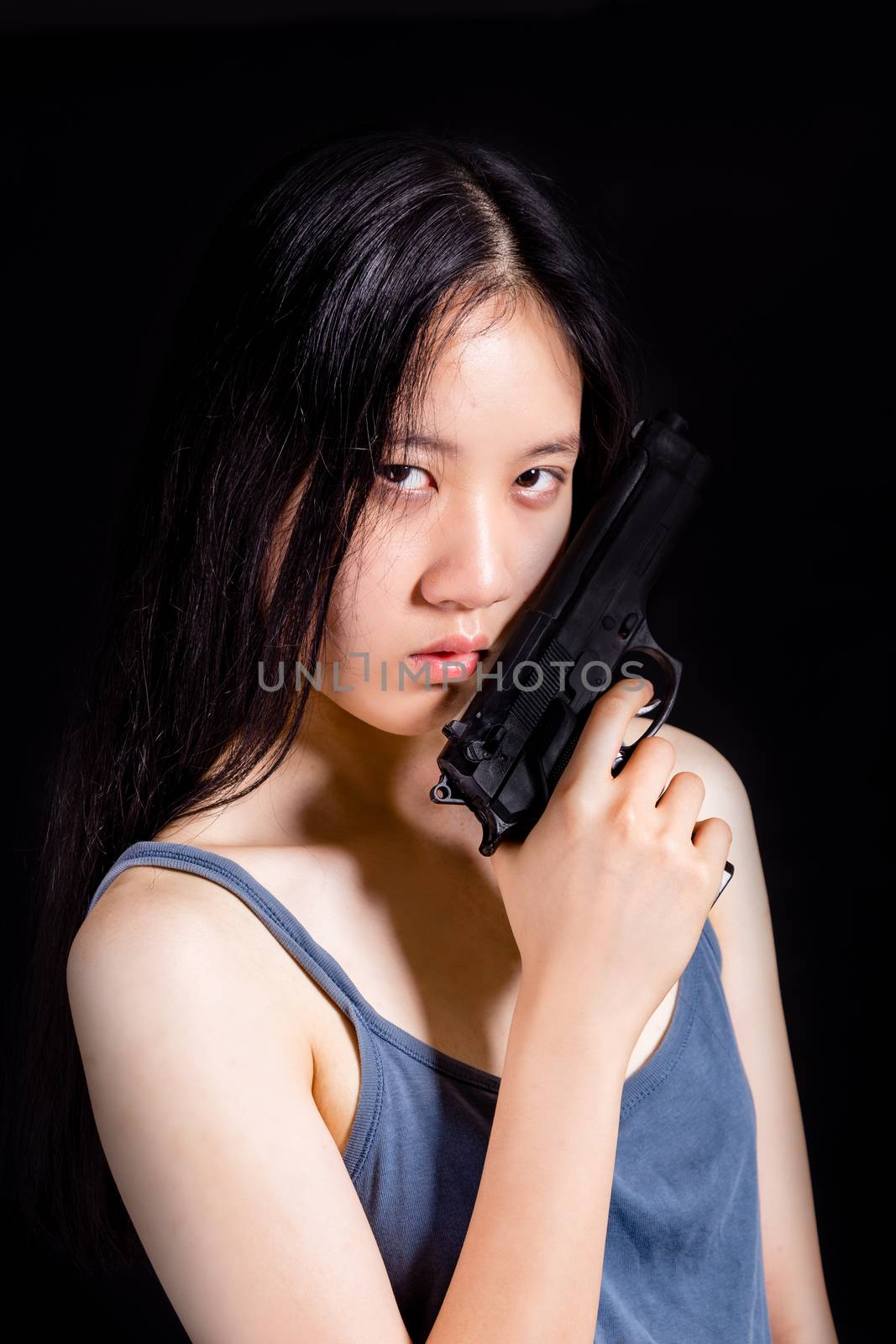 Teenage Asian American girl with handgun