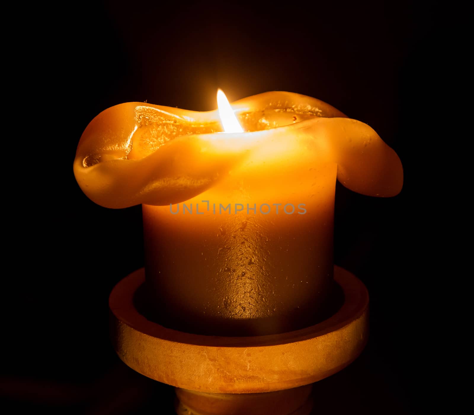 Large candle burning in the darkness, selective focus