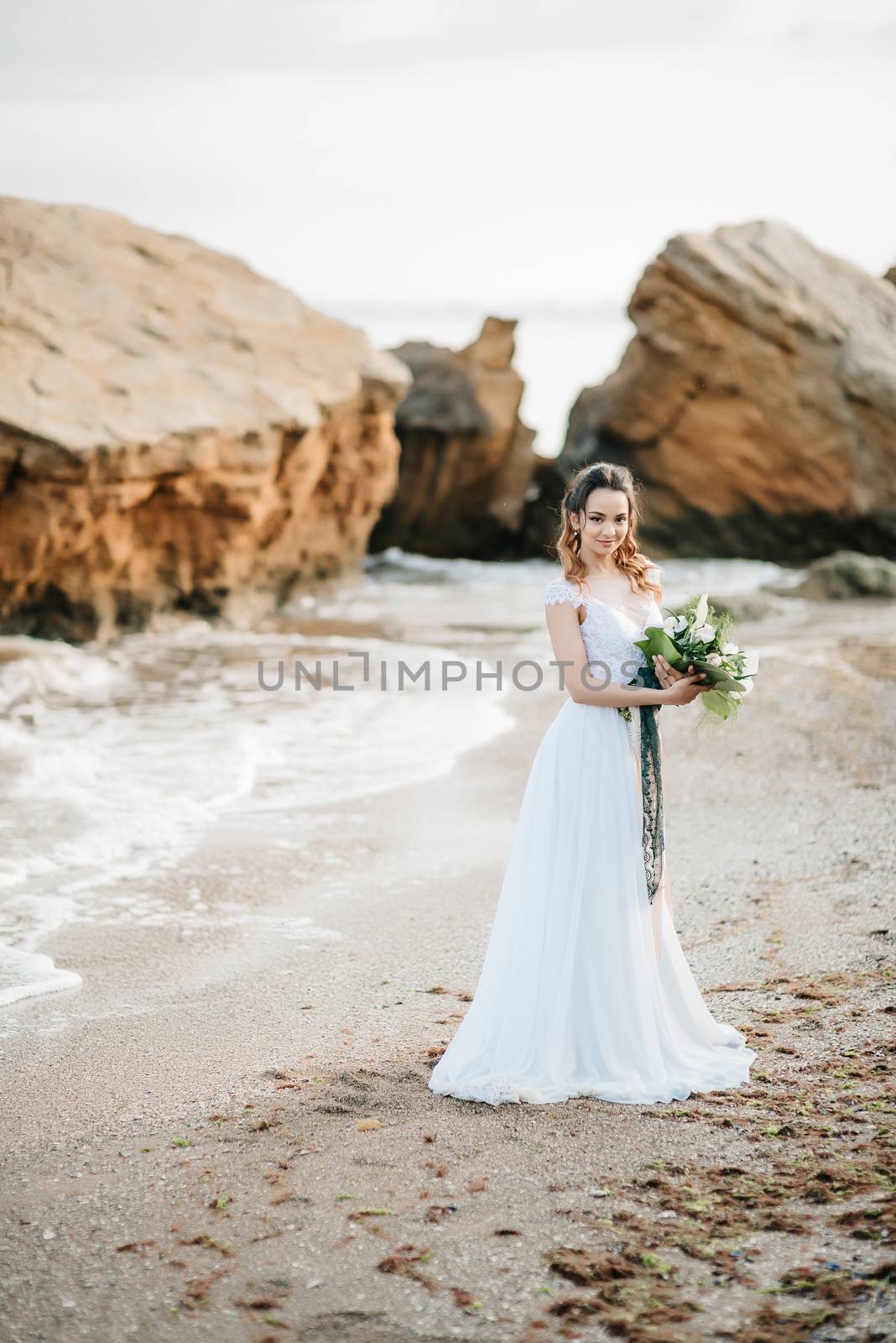 bride with a wedding bouquet on the shore  sea by Andreua