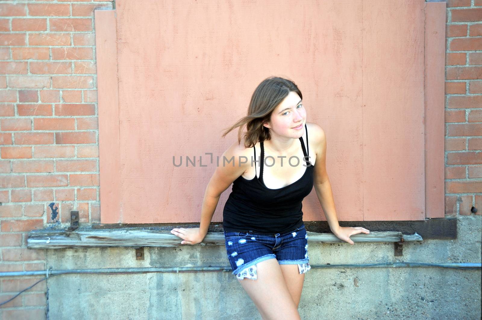 Female beauty expressions against a wall outside.