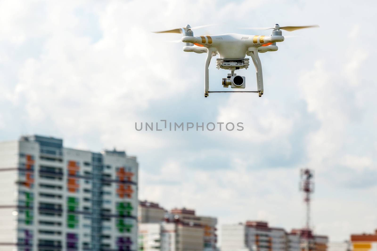 The drone flies in the sky in front of the houses which are under construction in the field