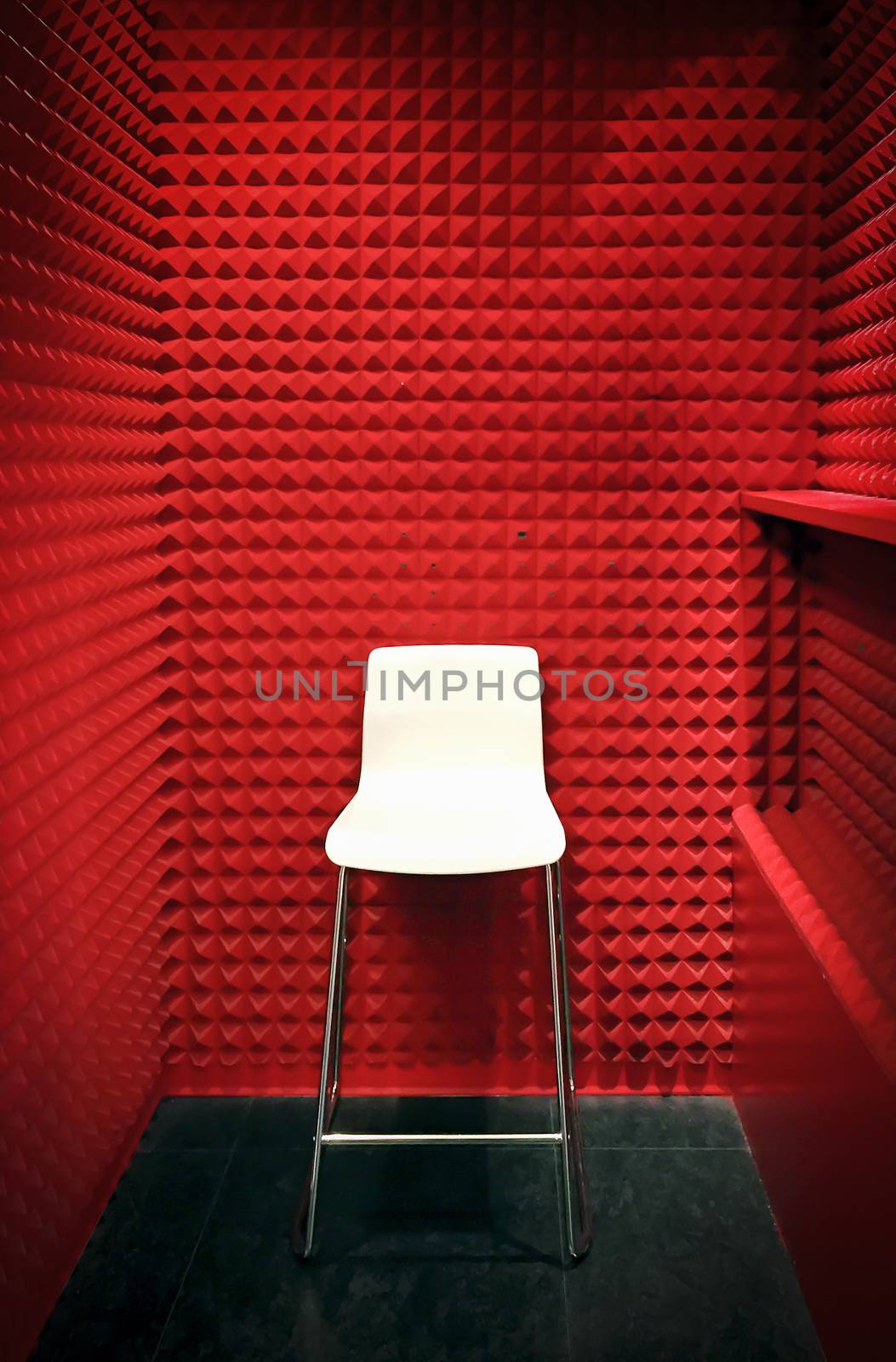 white stool in a red cabin with foam soundproof panels