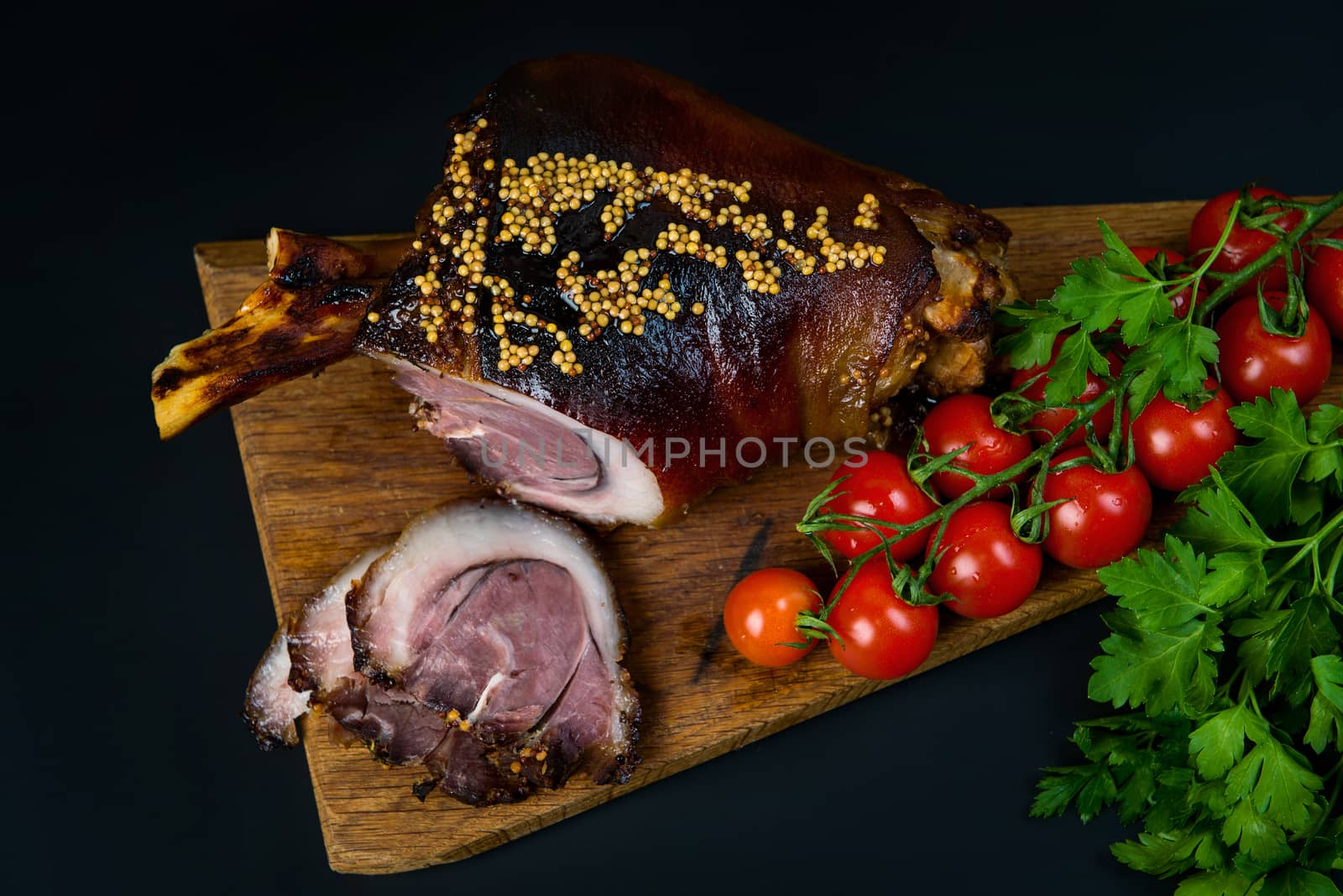 Roast pork knuckle and ingredients close-up on a slate board.  by Draw05