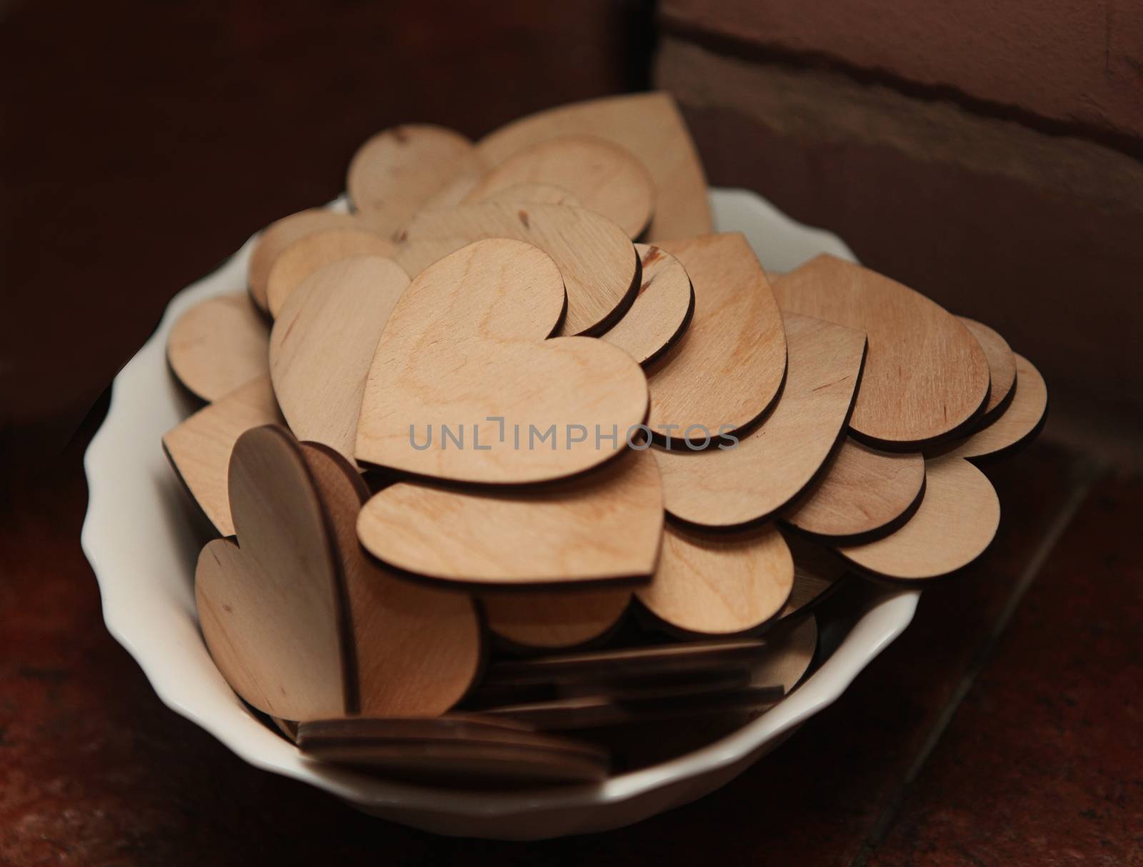 Carved wooden hearts on a white plate. by sermax55