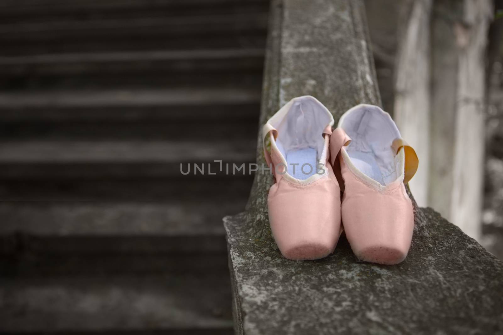 Pink pointe shoes for a classical ballerina, close-up on concrete