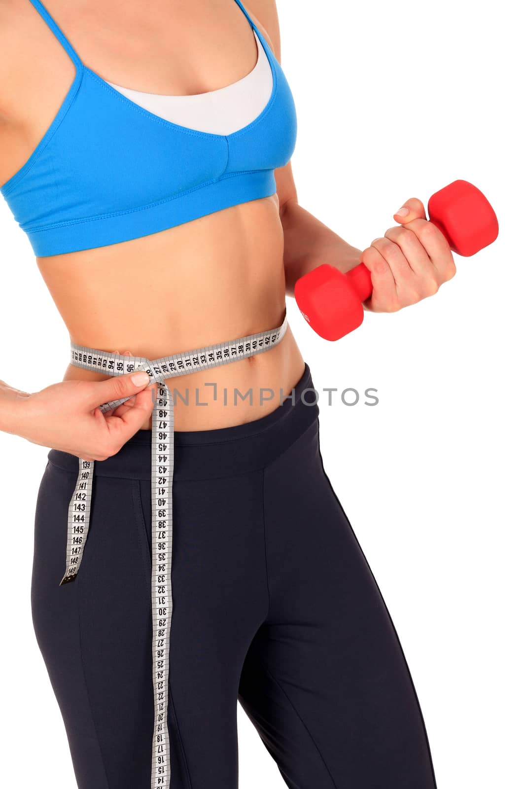 Closeup shot of slim young woman holding red dumbbell and measuring her thin waist with a tape measure, isolated on white background