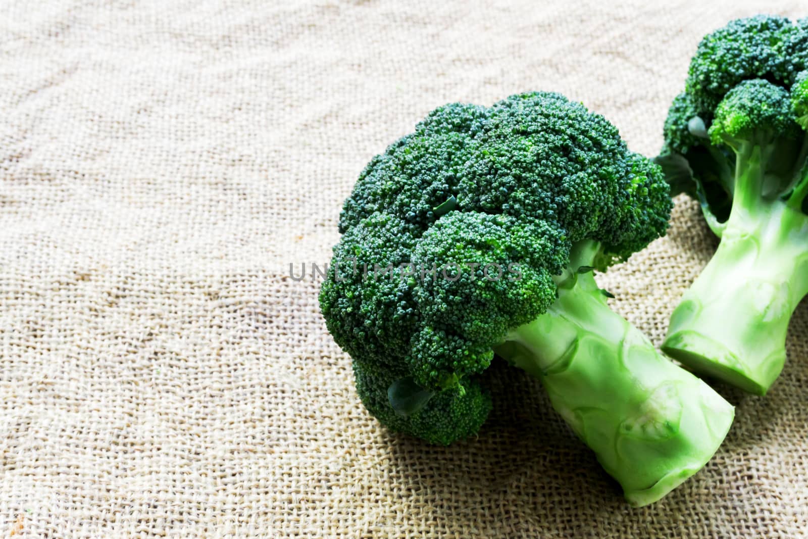 Closeup fresh broccoli on sackcloth background, raw food for cooking
