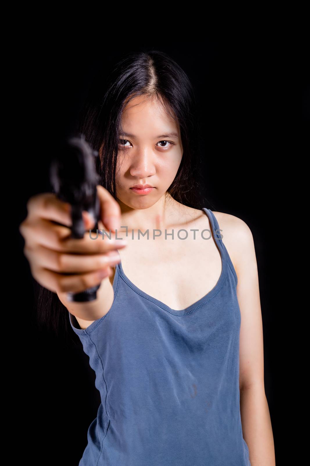 Teenage Asian American girl pointing handgun