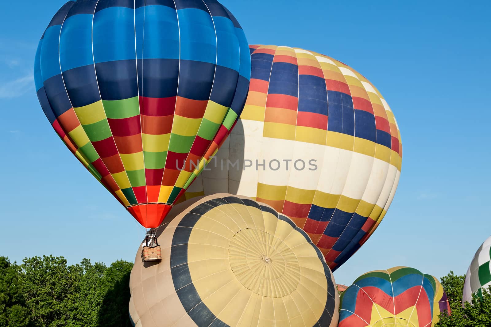 Colorful hot-air balloons ready to get up in flight against a blue sky