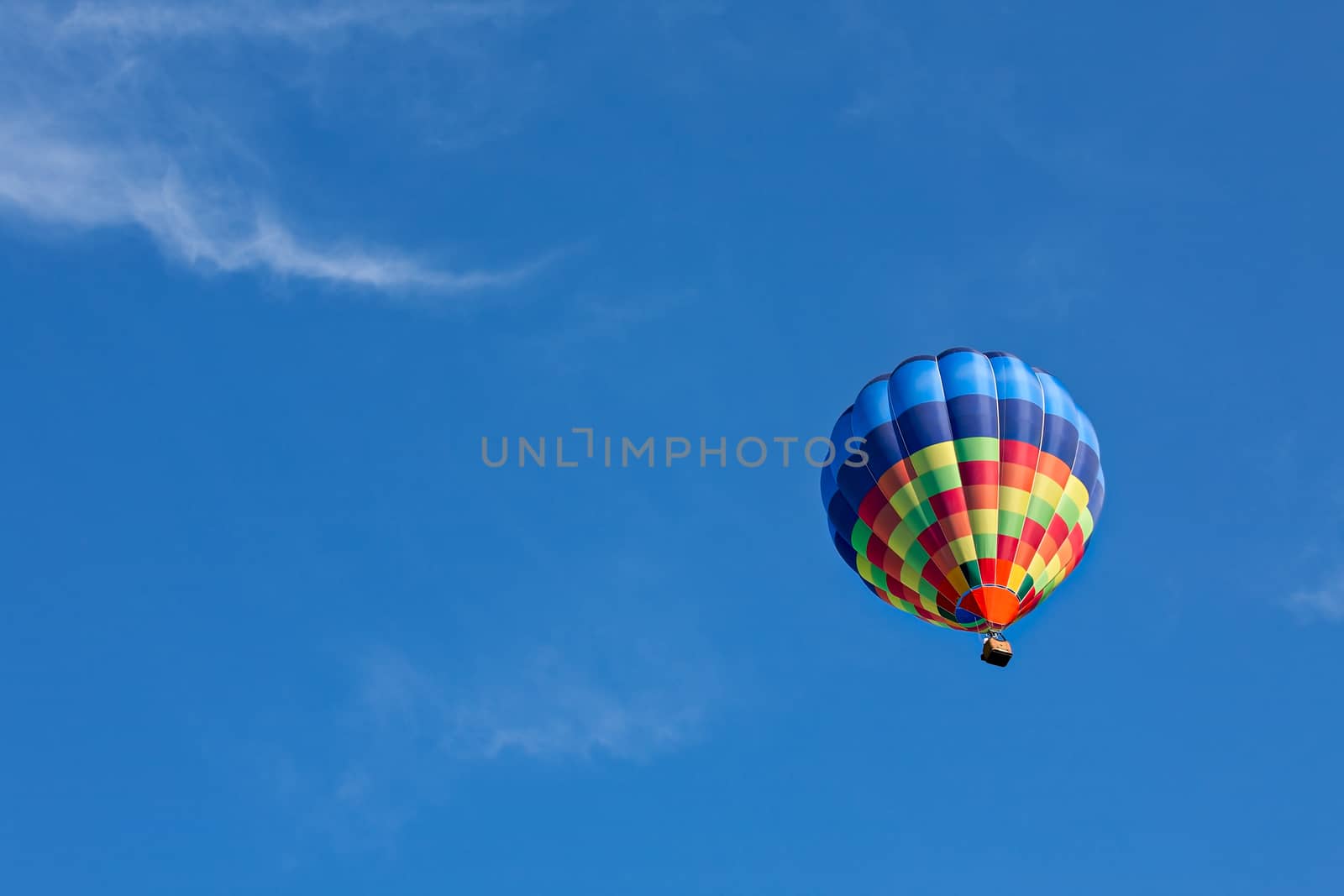 Colorful hot-air balloon in flight against a blue sky