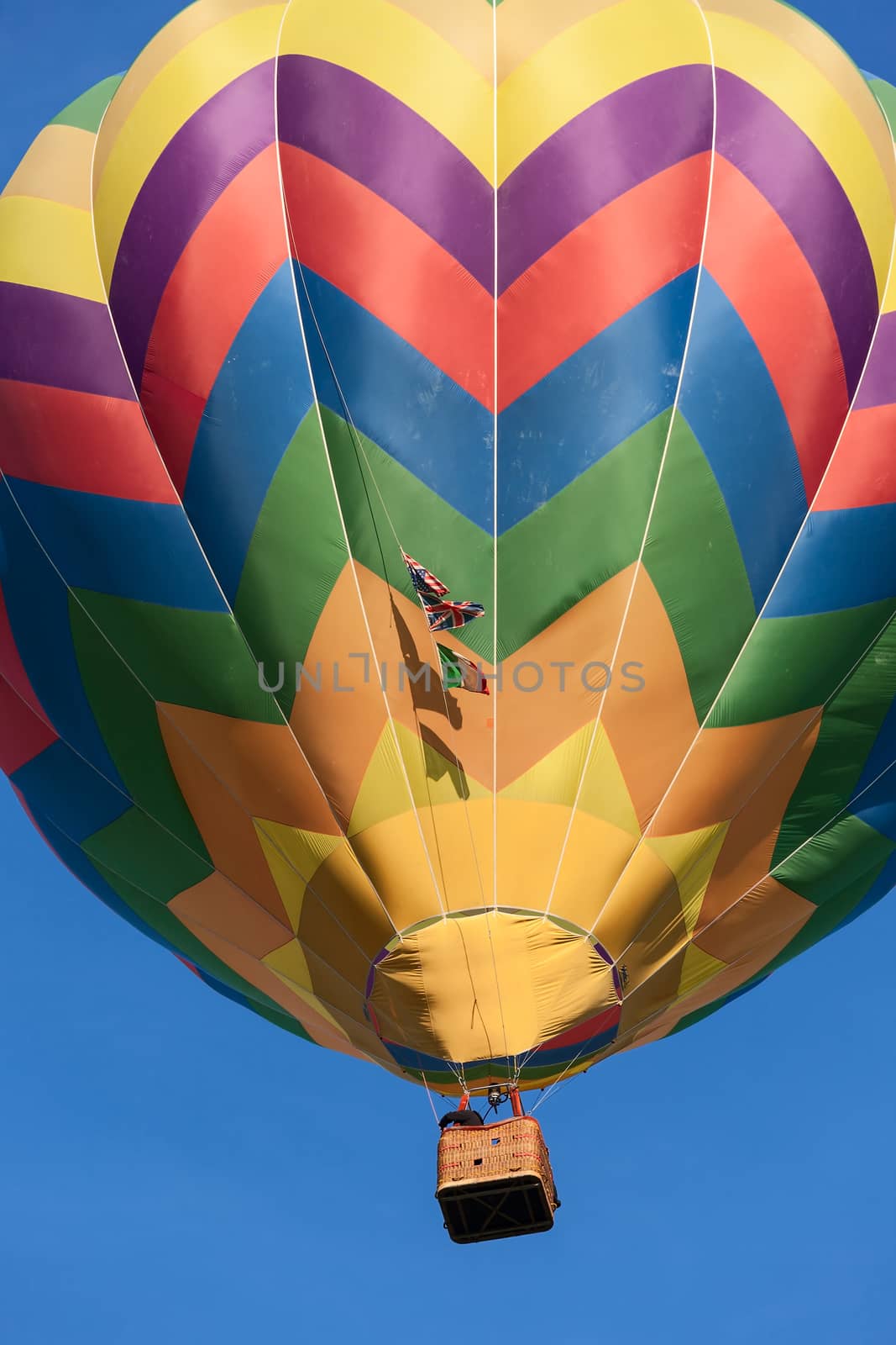 Colored hot-air balloon in flight against a blue sky