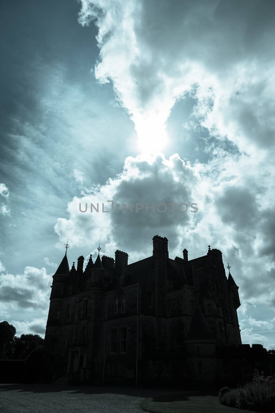 Dark silhouette scary looking medieval castle back-lit by sun by brians101