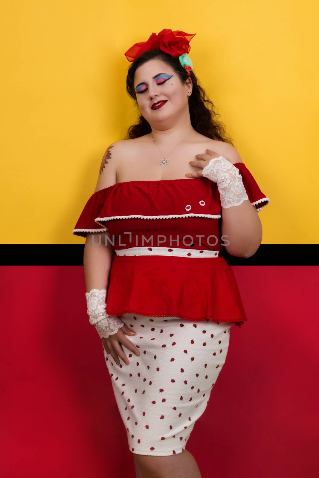 View of pinup vintage girl next to a colorful red and yellow background.