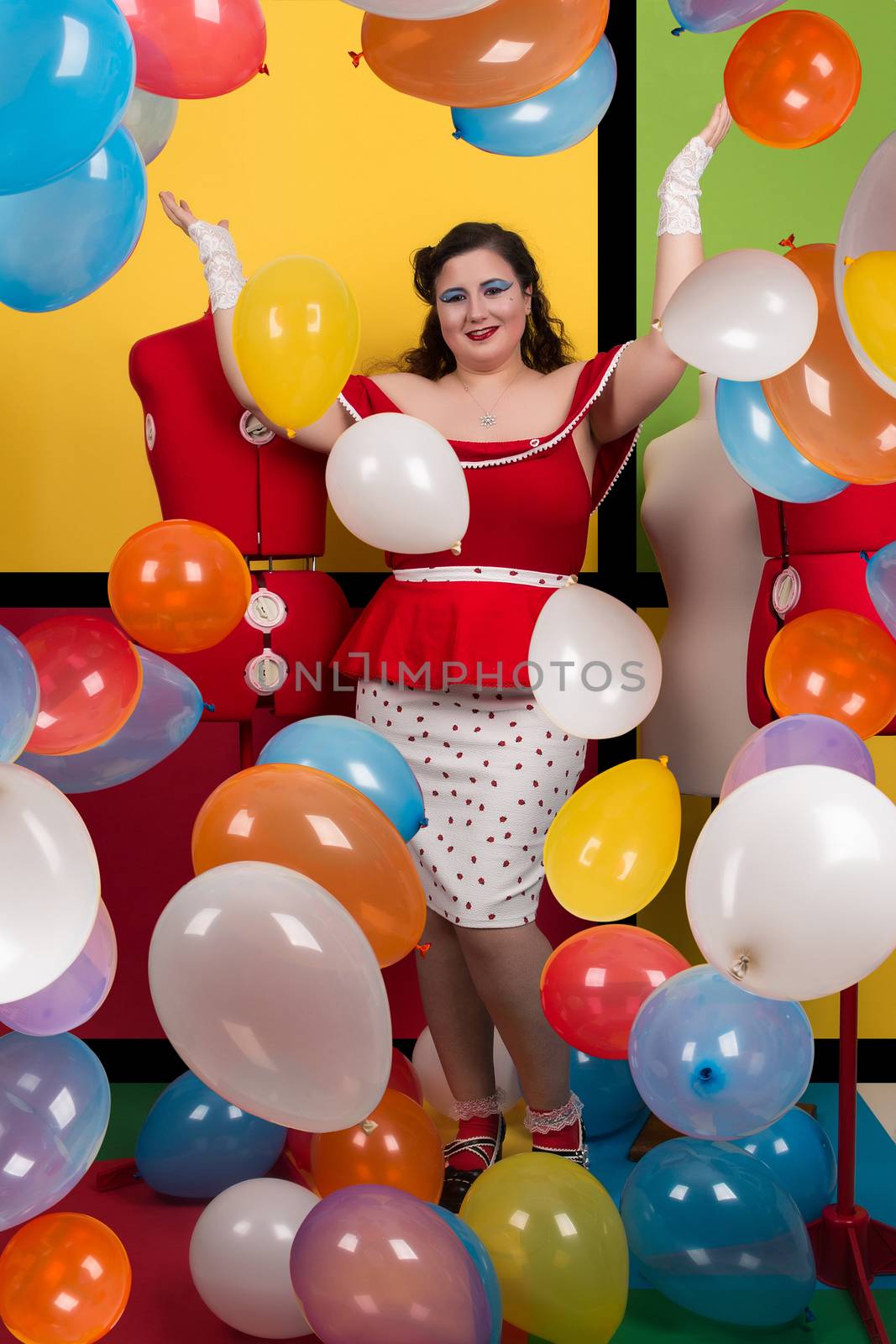 View of pinup vintage girl on a  colorful room filled with balloons.