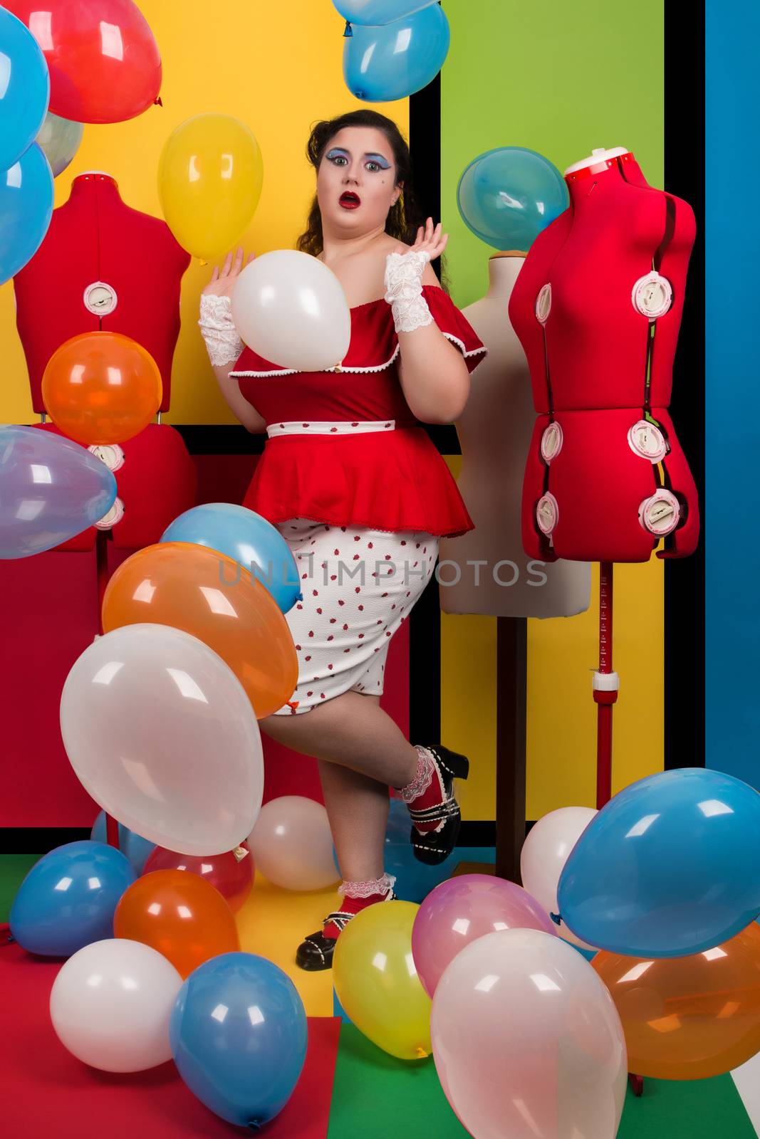 View of pinup vintage girl on a  colorful room filled with balloons.