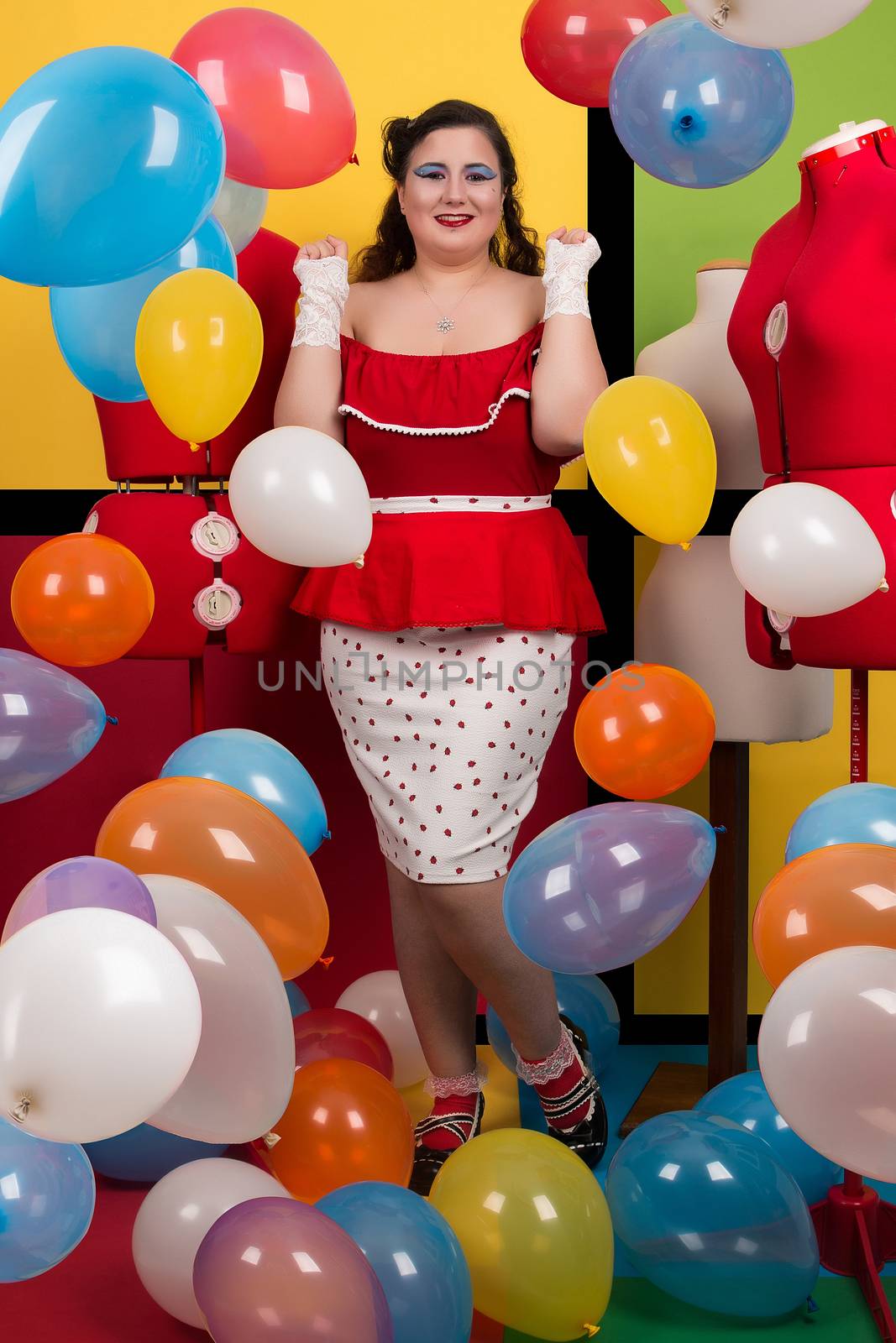 View of pinup vintage girl on a  colorful room filled with balloons.