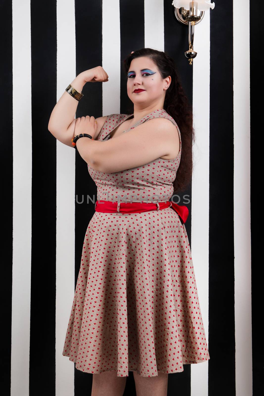 Pinup girl posing on a black and white stripes backdrop.