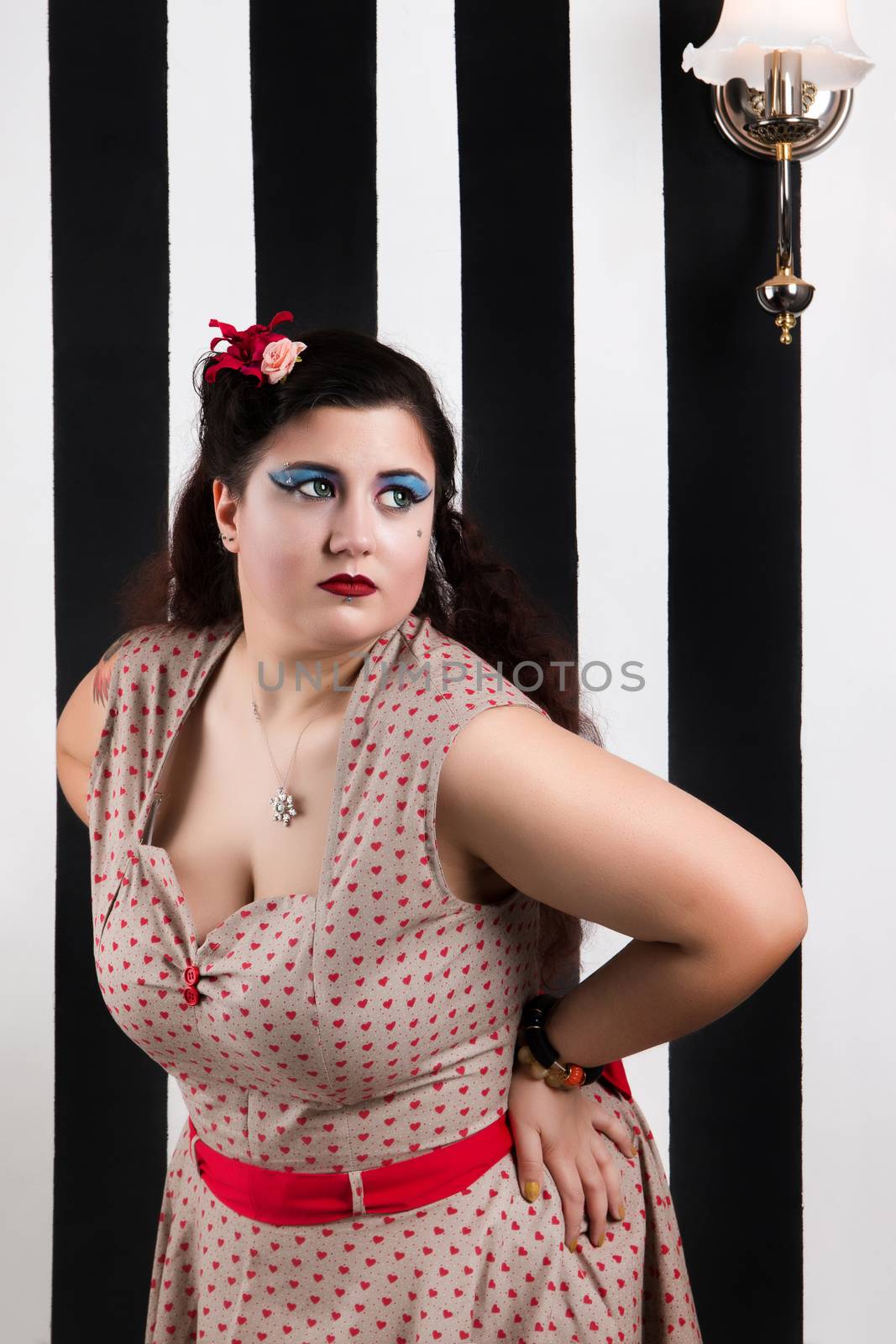 Pinup girl posing on a black and white stripes backdrop.