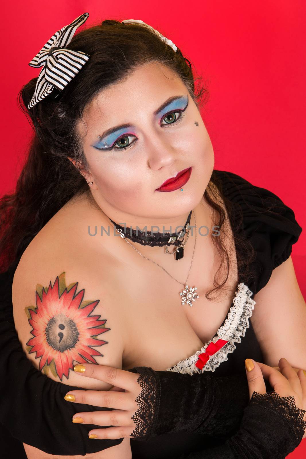 View of pinup vintage girl next to a colorfulred backdrop.