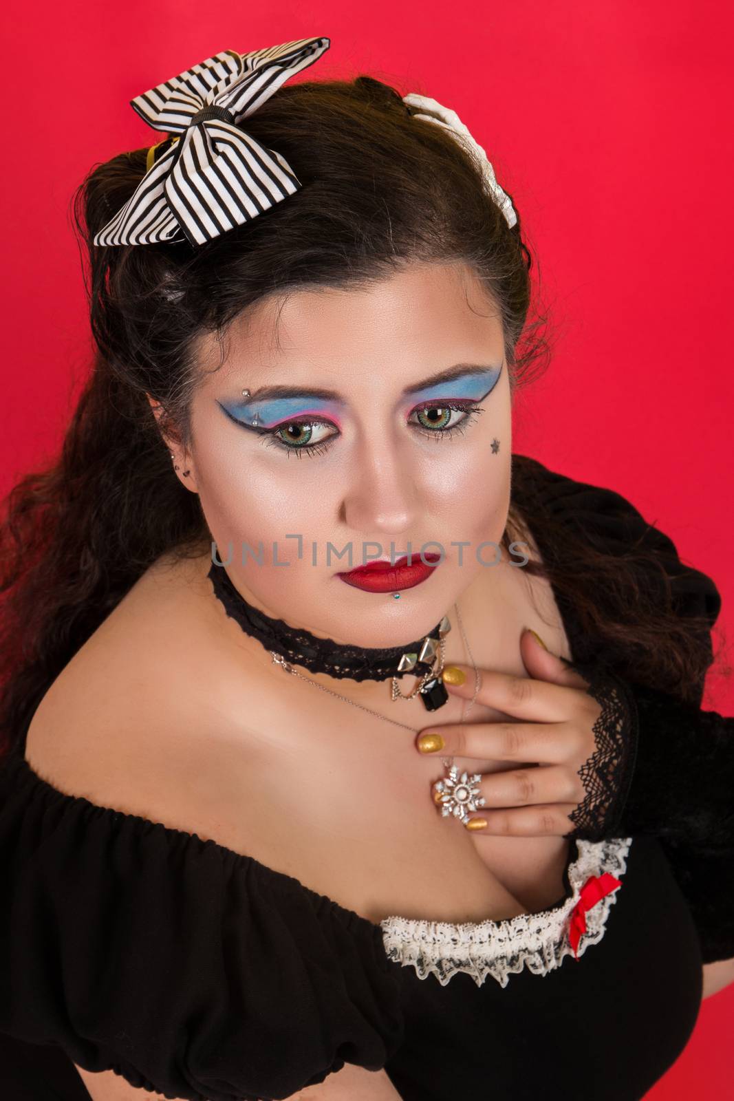 View of pinup vintage girl next to a colorfulred backdrop.