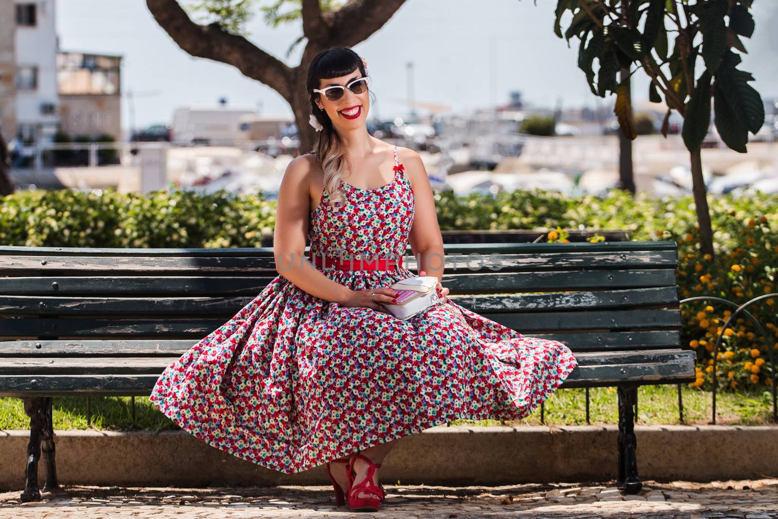 Pinup girl  with dress relaxing in the beautiful urban park.