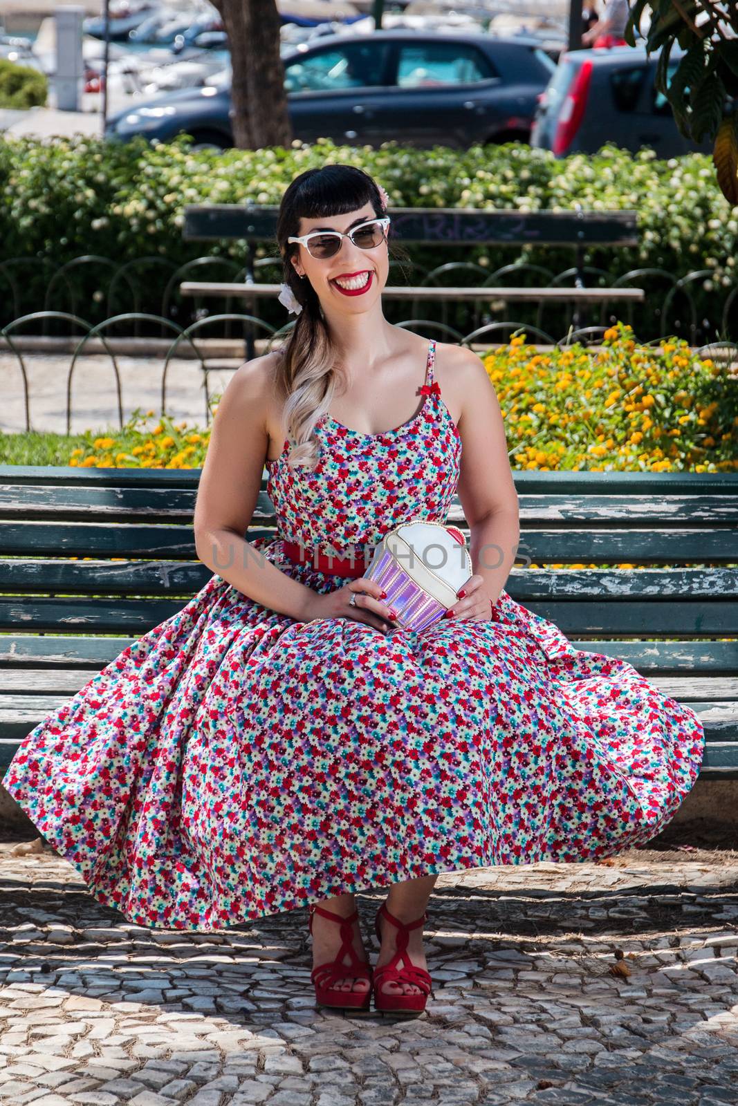 Pinup girl  with dress relaxing in the beautiful urban park.