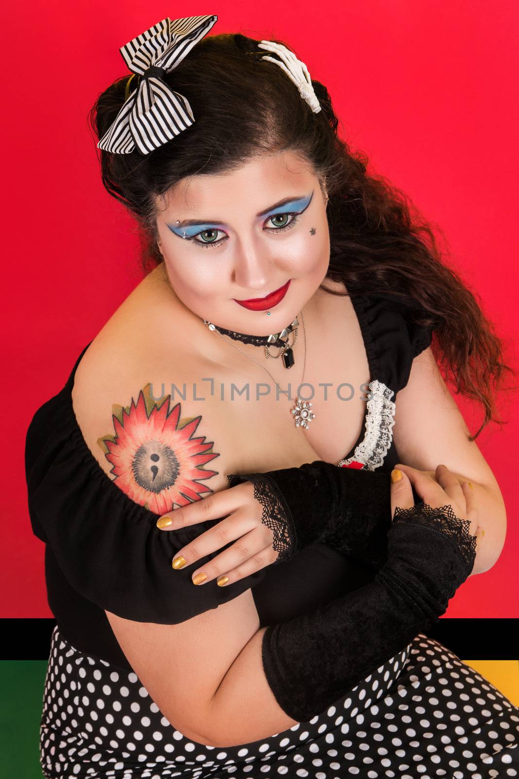 View of pinup vintage girl next to a colorfulred backdrop.