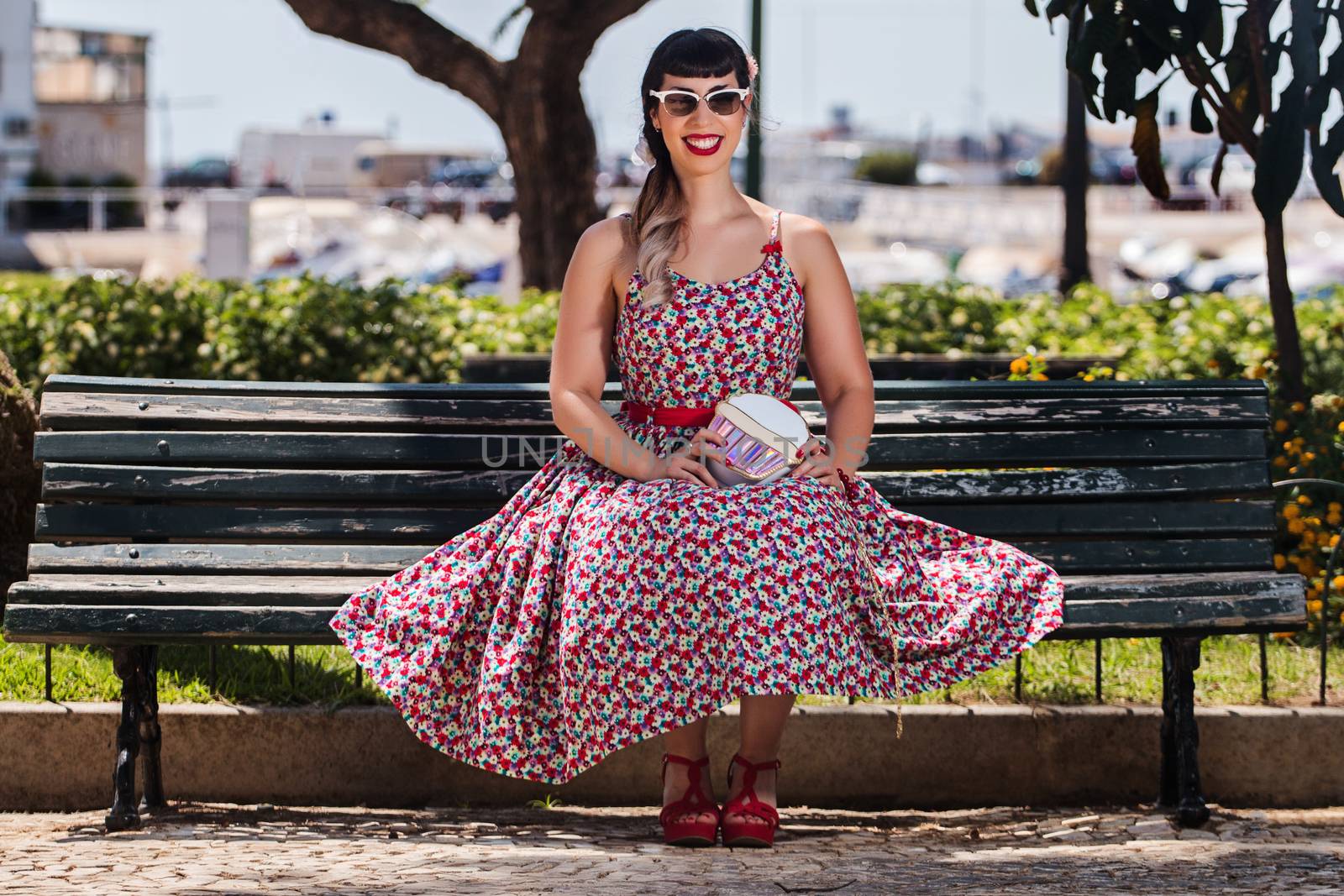 Pinup girl  with dress relaxing in the beautiful urban park.