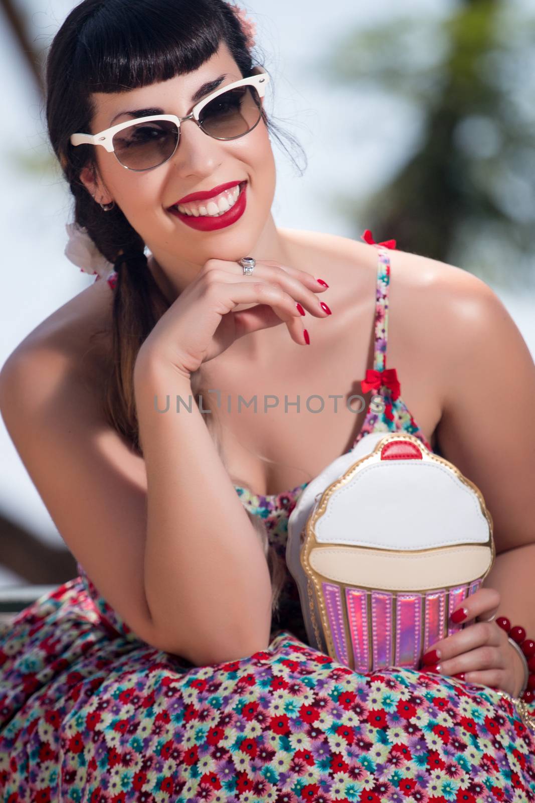 Pinup girl  with dress relaxing in the beautiful urban park.