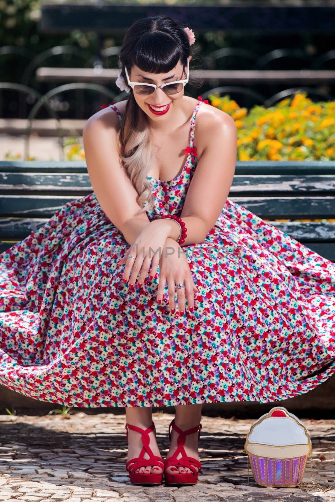 Pinup girl  with dress relaxing in the beautiful urban park.