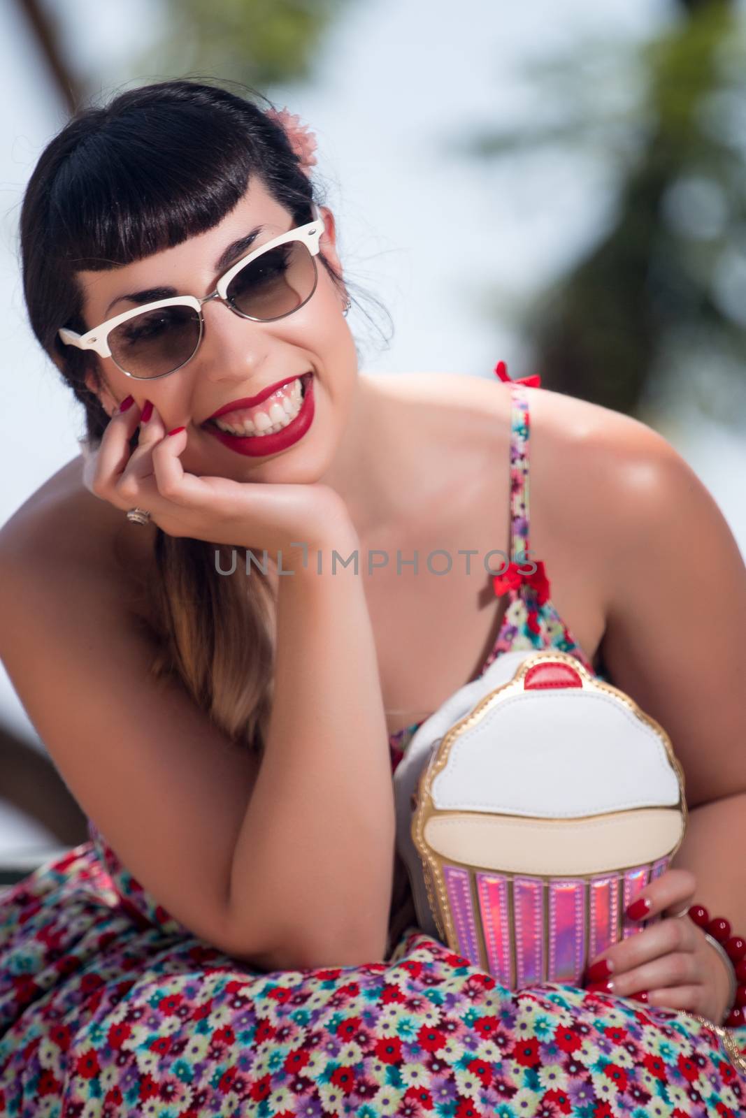 Pinup girl  with dress relaxing in the beautiful urban park.