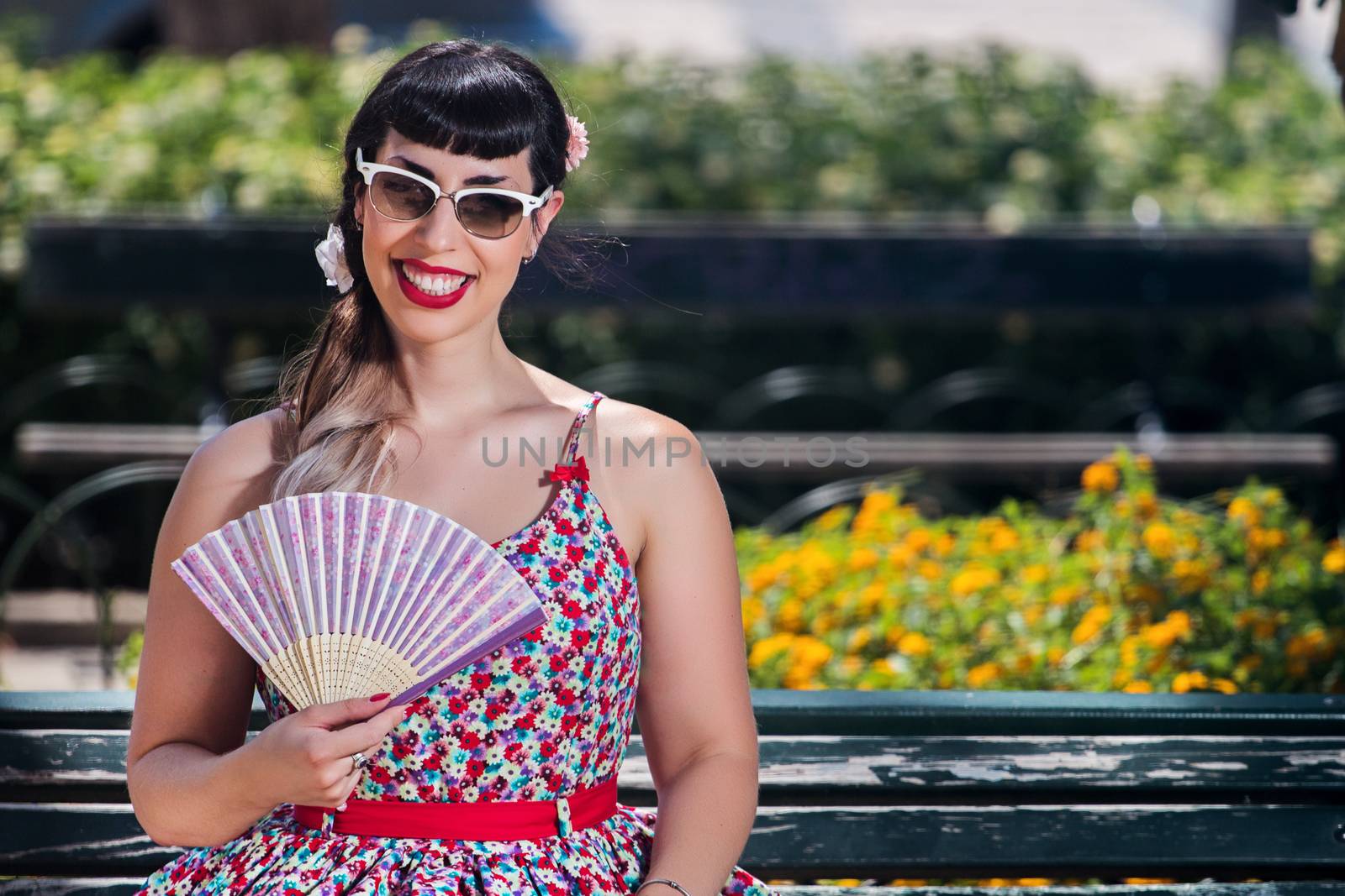 Pinup girl  with dress relaxing in the beautiful urban park.