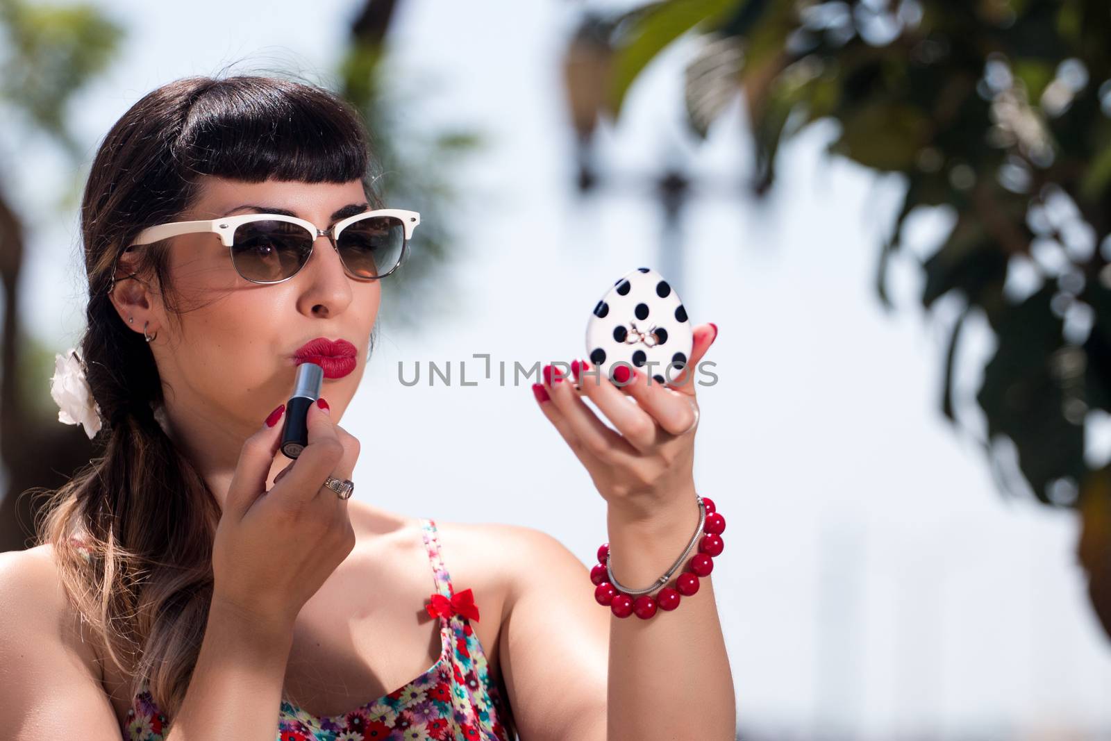 Pinup girl applying lipstick by membio