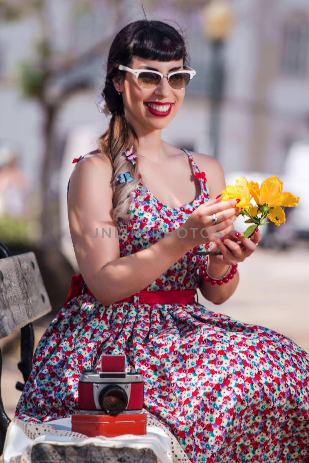 Pinup girl  with dress relaxing in the beautiful urban park.